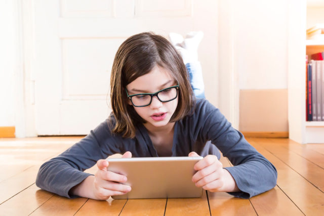 child with glasses and tablet lg